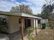 Home exterior featuring an attached awning and a backyard shed under a partly cloudy sky at 1130 E Bay St, Winter Garden, FL 34787