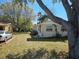 View of the front yard featuring mature trees, a well-maintained lawn, and the home's exterior at 1130 E Bay St, Winter Garden, FL 34787