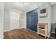 Inviting foyer with a striking blue double door, hardwood flooring, and a convenient wall-mounted organizer at 1183 Feather Dr, Deltona, FL 32725