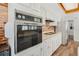 A kitchen with a brick backsplash and white cabinetry featuring a built-in oven at 1183 Feather Dr, Deltona, FL 32725