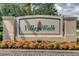 Village Walk community sign surrounded by colorful flowers and lush greenery at 11846 Nautica Dr, Orlando, FL 32827