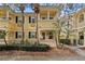 Charming yellow two-story townhome with black shutters, landscaped yard, and palm trees at 11846 Nautica Dr, Orlando, FL 32827