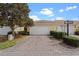 A charming home features a brick driveway and a two-car garage surrounded by lush greenery and manicured shrubs at 11846 Nautica Dr, Orlando, FL 32827