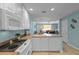 Kitchen with white cabinets, stove top, and a view into the living area at 11846 Nautica Dr, Orlando, FL 32827