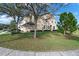 The exterior of the townhome displays its well-kept lawn, two-car garage, and lovely landscaping at 1335 E 10Th St, Apopka, FL 32703