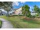 Townhome exterior showcasing the manicured front lawn with beautiful landscaping and convenient sidewalk access at 1335 E 10Th St, Apopka, FL 32703