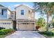 Charming two-story townhouse featuring a paved driveway and attached two-car garage at 1335 E 10Th St, Apopka, FL 32703