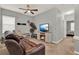 Cozy carpeted living room with a ceiling fan, a fireplace, and a comfortable sofa for relaxation at 1335 E 10Th St, Apopka, FL 32703