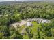 Aerial view showcases the horse facility with ample parking, training ring, and paddocks at 136 Raintree Dr, Longwood, FL 32779