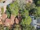 Aerial view of a brown roofed home nestled among mature trees in a quiet neighborhood at 136 Raintree Dr, Longwood, FL 32779