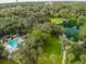 Stunning aerial view of a pool, lake, lush trees, and walking paths at 136 Raintree Dr, Longwood, FL 32779