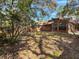 A spacious backyard with mature trees providing shade, a red fence offering privacy at 136 Raintree Dr, Longwood, FL 32779