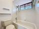 Bright bathroom featuring a shower-tub combo with white tile and unique shelving for added convenience at 136 Raintree Dr, Longwood, FL 32779