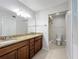 Bathroom features double sink vanity with granite countertop and tiled shower at 136 Raintree Dr, Longwood, FL 32779