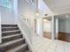 Bright entryway featuring a staircase and tile flooring, leading to adjacent living spaces with hardwood floors at 136 Raintree Dr, Longwood, FL 32779