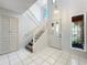 Bright entryway with white tile flooring, staircase, and a front door with glass panes at 136 Raintree Dr, Longwood, FL 32779