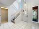 Bright entryway with white tile flooring, staircase, and a front door with glass panes at 136 Raintree Dr, Longwood, FL 32779