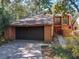 Two-story home with brown siding, brown shingled roof, a brown garage door, and a pop of color with a red front door at 136 Raintree Dr, Longwood, FL 32779