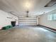 Spacious two-car garage with functional door, shelving, and window for natural light at 136 Raintree Dr, Longwood, FL 32779