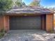 Spacious two car garage featuring a dark brown door and paver driveway at 136 Raintree Dr, Longwood, FL 32779