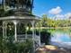 Picturesque white gazebo overlooking a tranquil lake and lush foliage at 136 Raintree Dr, Longwood, FL 32779