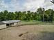 Large horse arena with fencing and a storage building, with trees in the background at 136 Raintree Dr, Longwood, FL 32779