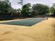 Wide angle view of tennis court with green court and yellow out-of-bounds area at 136 Raintree Dr, Longwood, FL 32779