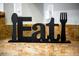 A modern table decoration spelling out EAT with a spoon and fork at 1371 Tuscan Terrace # 3203, Davenport, FL 33896