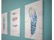 Close up of three decorative, framed canvas prints featuring feathers on a blue wall at 1371 Tuscan Terrace # 3203, Davenport, FL 33896