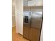 Stainless steel refrigerator in a modern kitchen, complemented by white cabinets and tile floors at 1422 Spalding Rd, Winter Springs, FL 32708