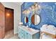 Bathroom with dual sinks, maritime themed wallpaper, rustic wood accents, and nautical lighting at 1427 Fairview Cir, Reunion, FL 34747