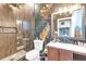 Stylish bathroom featuring a glass-enclosed shower, modern vanity, and tropical-themed wallpaper at 1427 Fairview Cir, Reunion, FL 34747