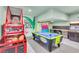 Bright game room showcasing a basketball arcade game, air hockey table, and playful wall decorations for Gathering fun at 1427 Fairview Cir, Reunion, FL 34747