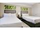 Inviting bedroom with two beds, lamps, and artwork over the headboards at 14501 Grove Resort Ave # 2522, Winter Garden, FL 34787