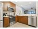Well-equipped kitchen with modern stainless steel appliances and wood cabinets, and open to the living area at 14501 Grove Resort Ave # 2522, Winter Garden, FL 34787