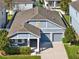 Aerial view of a blue house with a 3-car garage, covered porch, and a manicured yard at 15255 Honeybell Dr, Winter Garden, FL 34787