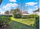 Scenic view of the backyard with lush landscaping, green grass, and a young tree at 15255 Honeybell Dr, Winter Garden, FL 34787