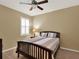 Bedroom with a ceiling fan, neutral walls, shuttered window and wood furniture at 15255 Honeybell Dr, Winter Garden, FL 34787