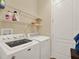 Bright laundry room with a white washer, dryer, shelving, and a door at 15255 Honeybell Dr, Winter Garden, FL 34787