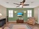 Living room with a ceiling fan, large screen television, and stylish sconce lighting at 15255 Honeybell Dr, Winter Garden, FL 34787