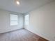 Neutral bedroom with carpeted floors and bright, natural lighting from the window at 1549 Discovery St, Davenport, FL 33896