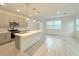 Open-concept kitchen featuring stainless steel appliances, a large island, stylish pendant lighting, and sleek gray cabinetry at 1549 Discovery St, Davenport, FL 33896