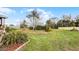 The expansive backyard showcases a large grassy area, trimmed bushes, and mature trees at 1562 Auburn Oaks Ct, Auburndale, FL 33823