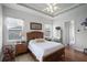 Comfortable bedroom featuring a ceiling fan, wood floors, and lots of natural light from the windows at 1562 Auburn Oaks Ct, Auburndale, FL 33823