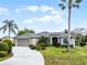 Charming single-story home with a well-manicured lawn, large driveway, and a lush tropical landscape at 1562 Auburn Oaks Ct, Auburndale, FL 33823