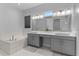 Serene bathroom featuring a soaking tub and double vanity sinks with elegant fixtures at 15644 Panther Lake Dr, Winter Garden, FL 34787