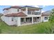 A covered patio and balcony offer relaxation space in this home with large sliding glass doors and a manicured lawn at 15644 Panther Lake Dr, Winter Garden, FL 34787