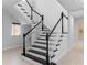 Modern staircase with black treads and white risers and railings in a bright, open space at 15644 Panther Lake Dr, Winter Garden, FL 34787