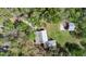 An aerial view showcasing a house with a metal roof accompanied by an outbuilding, amidst a verdant landscape at 16318 Hamilton Dr, Orlando, FL 32833