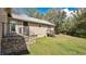 Backyard featuring stairs to the back door, a small stone wall, and grass at 16318 Hamilton Dr, Orlando, FL 32833